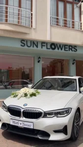Beyaz araç kaputu üzerinde beyaz güller ve beyaz gerberalar.