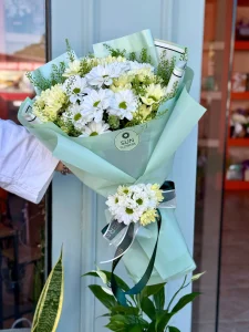 Ferah mint yeşili ambalaj içerisinde masum beyaz papatya buketi