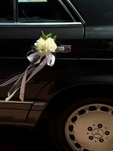 Siyah klasik Mercedes gelin arabası kapı kolunda taze beyaz çiçek süslemesi