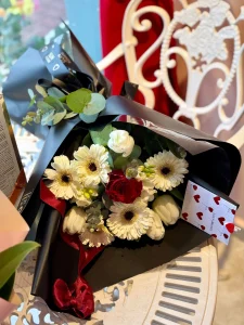 Klasik siyah ambalajında kontrast yaratan asil beyaz gerbera ve kırmızı gül buketi