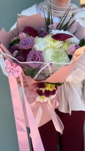 Zarif toz pembe ambalaj kağıdına sarılmış beyaz kasımpatı ve egzotik bordo gala çiçeği el buketi